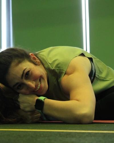 Diala resting on a yoga mat, smiling